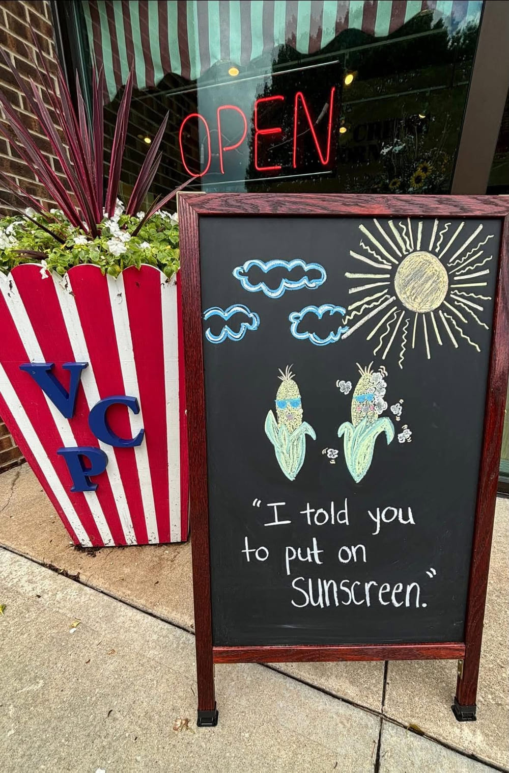 Velvet Creme storefront chalkboard with a summer popcorn joke